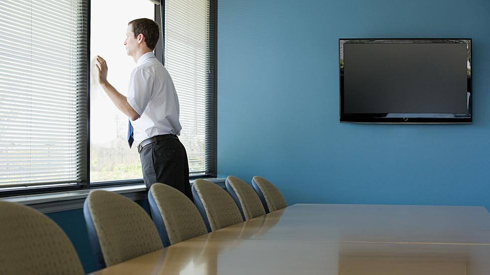 Office worker looking through window