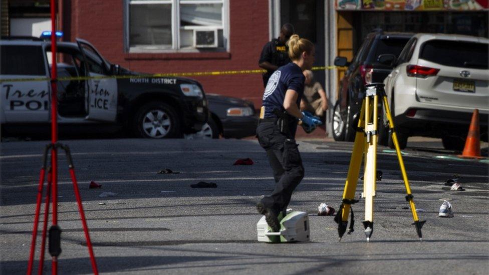 Police officers inspect the crime scene at the Roebling Market in Trenton on 17 June, 2018