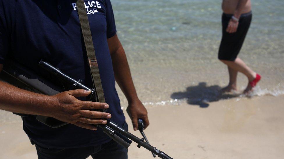 A Tunisian police officer guards the beach in front of the Imperial Marhaba Hotel in Sousse, Tunisia, Sunday, June 28, 2015.