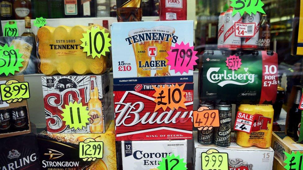 Bottles and cans of liquor are displayed with price tags in a shop window in Glasgow