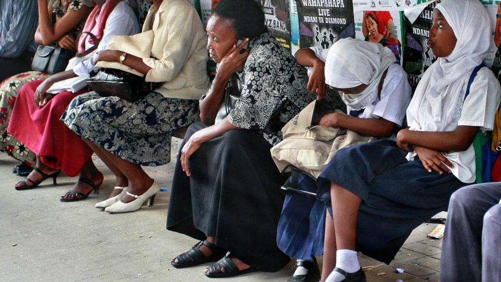 People waiting on a bench in Dar es Salaam, Tanzania