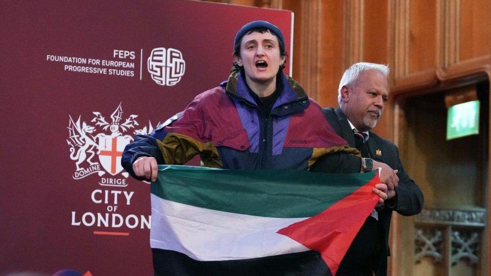 A protester interrupts the shadow foreign secretary's speech