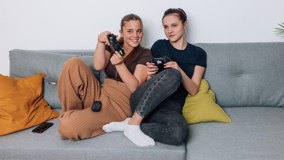 Girls gaming on sofa