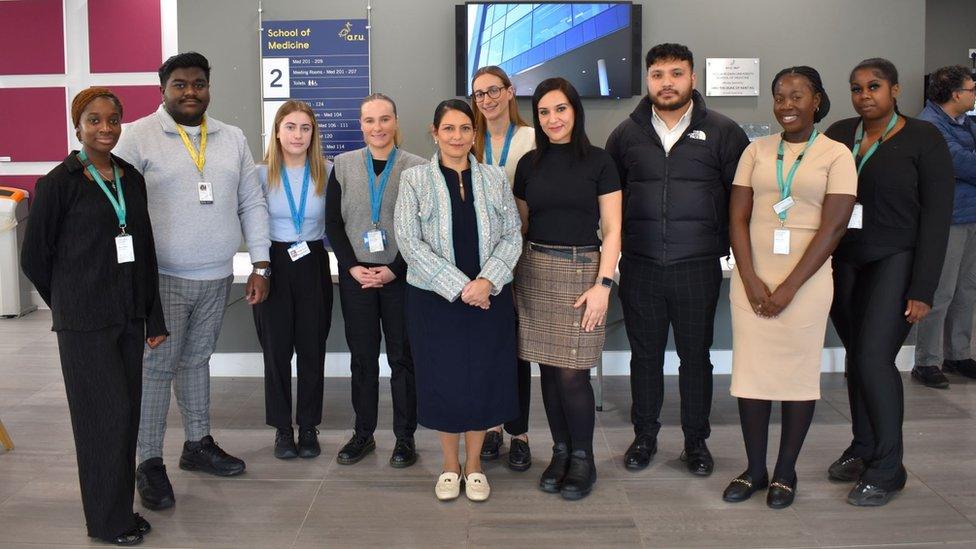 Priti Patel standing with students at Anglia Ruskin University's medical school