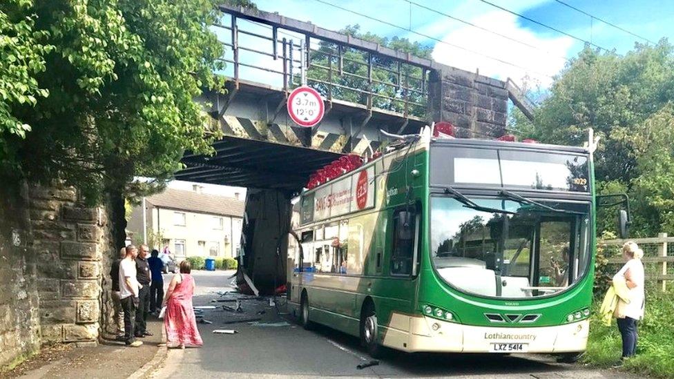 Bus jammed under bridge