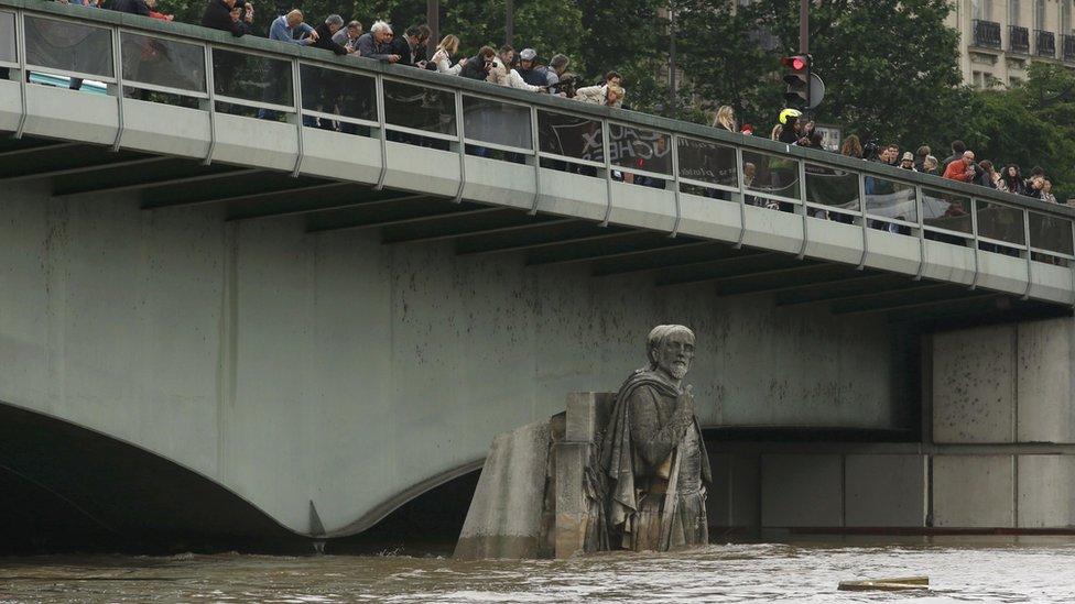 Crowd on the Alma bridge in 2016 - the water only reaches the Zouave's upper legs