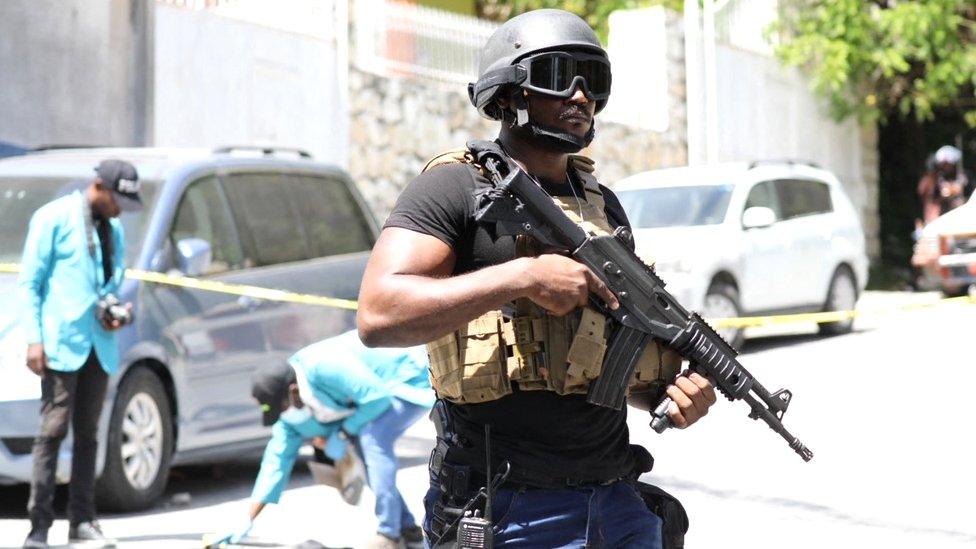 Members of the Haitian police and forensics look for evidence outside of the presidential residence