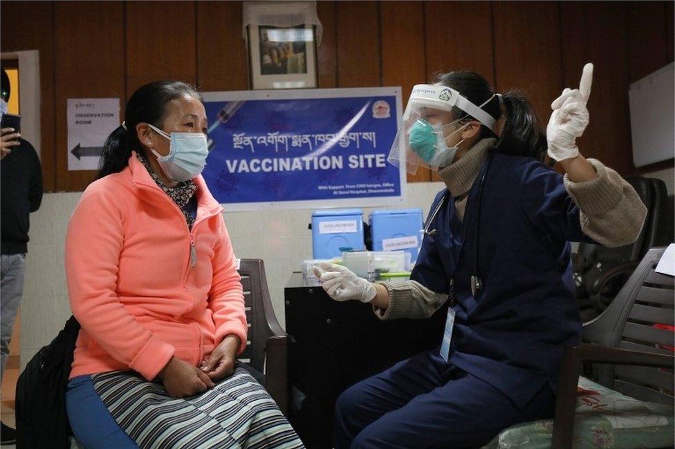 A health worker is seen with a Tibetan woman inside a room during a dry run of Covid-19 vaccination inside a vaccination centre at Delek Hospital in Dharamsala, India