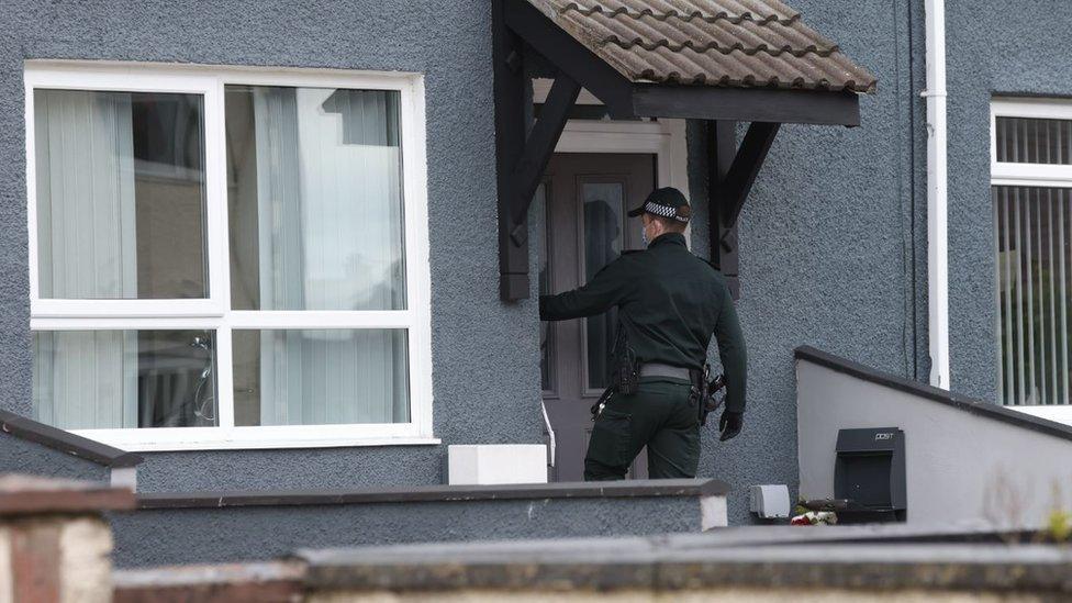 A member of the Paramilitary Crime Task Force standing at the front door of a house