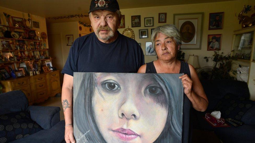 oe and Thelma Favel and a framed collage tribute to their niece, Tina Fontaine, who was murdered and her body dumped in the Red River