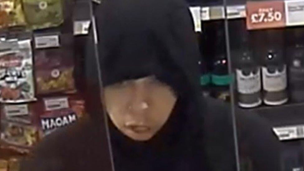 CCTV image of a man in a black hooded top