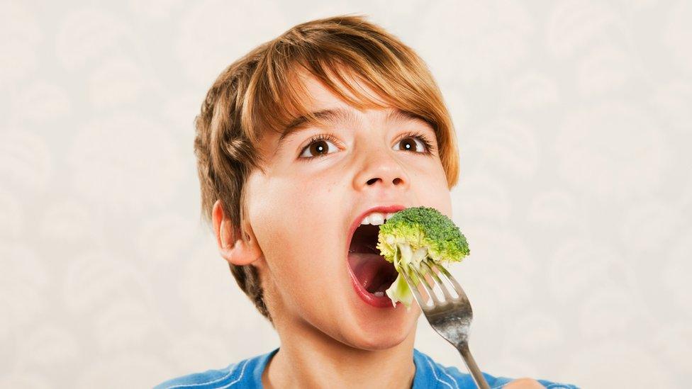 Boy eating brocolli