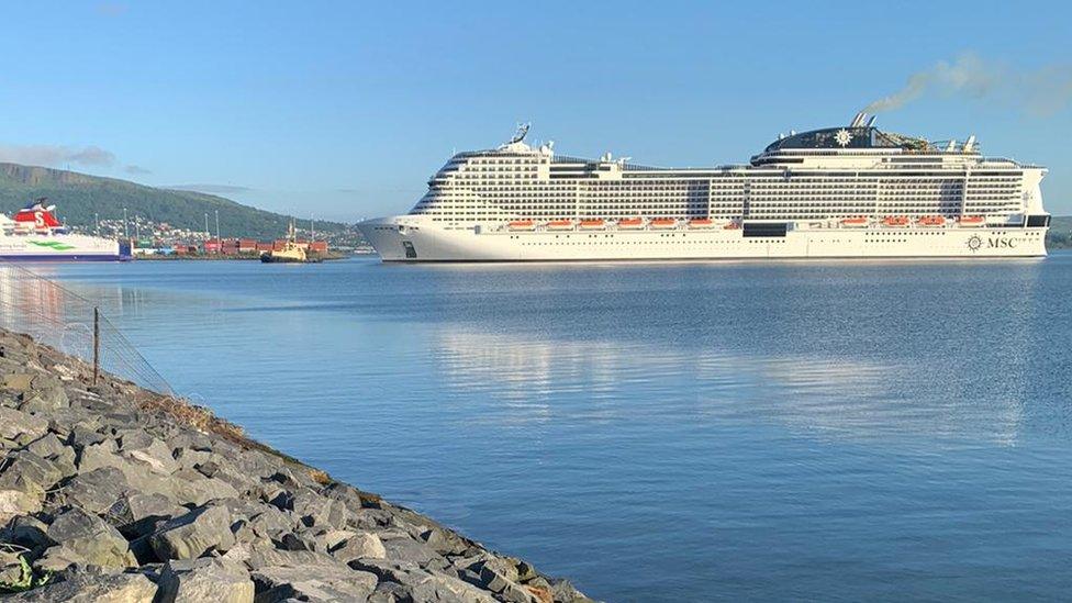 The MSC Virtuosa pictured from the shore in Belfast on a clear day, with a side view showing the size of the vessel