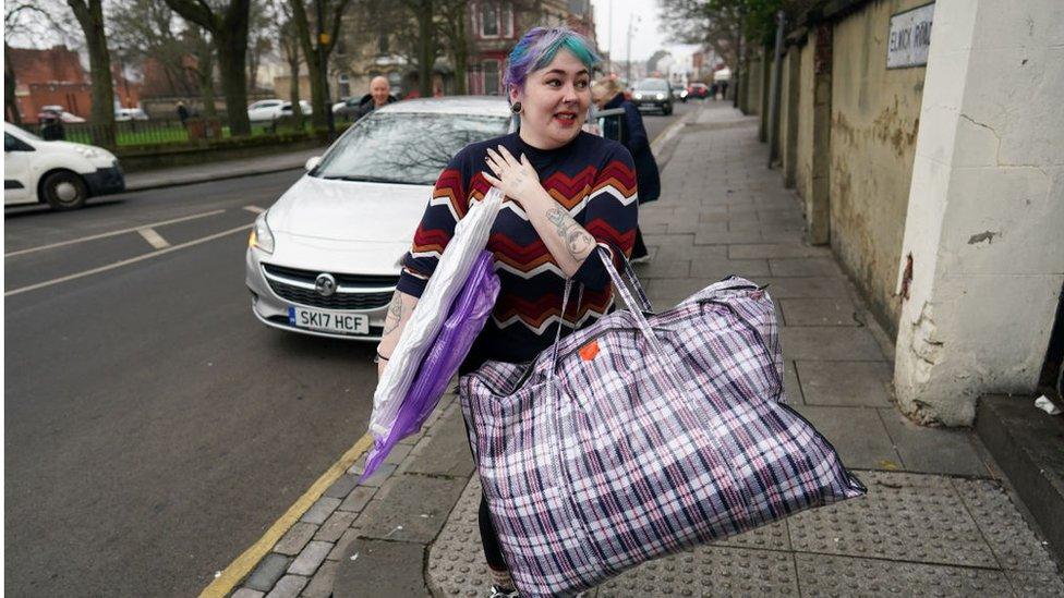 A volunteer carries donations through a street in Hartlepool