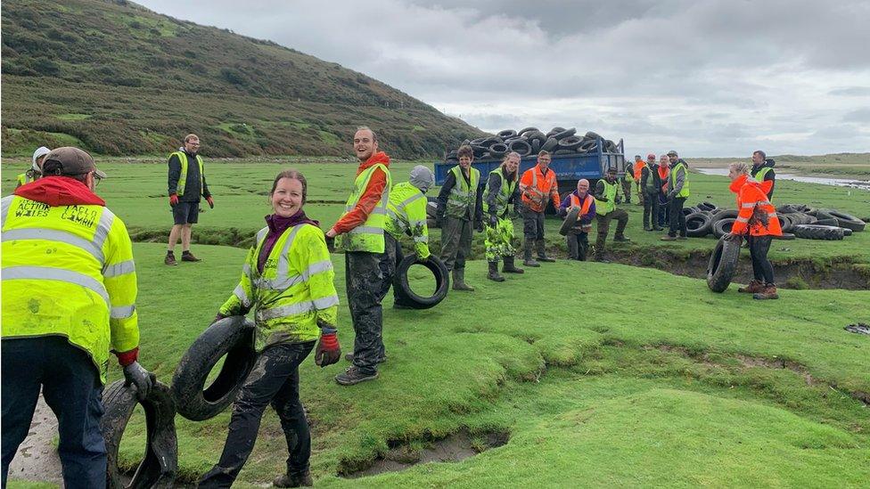 A line of volunteers passing tyres