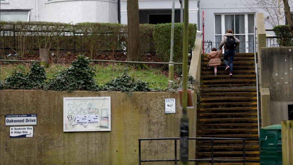 File image of a woman and a child climbing up concrete steps leading out of a housing estate in south London