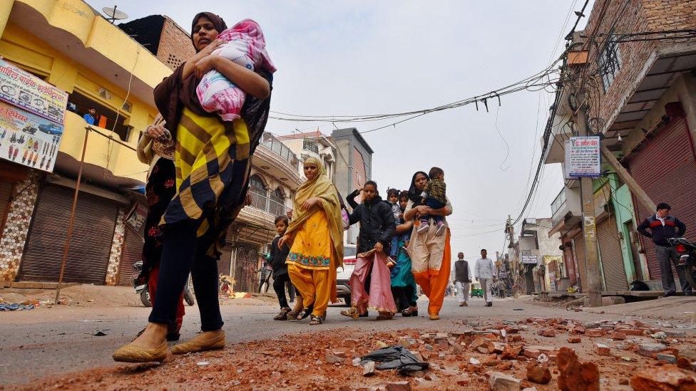 People leave their houses following communal violence over the Citizenship Amendment Act (CAA), in Shiv Vihar area on February 27, 2020 in New Delhi, India