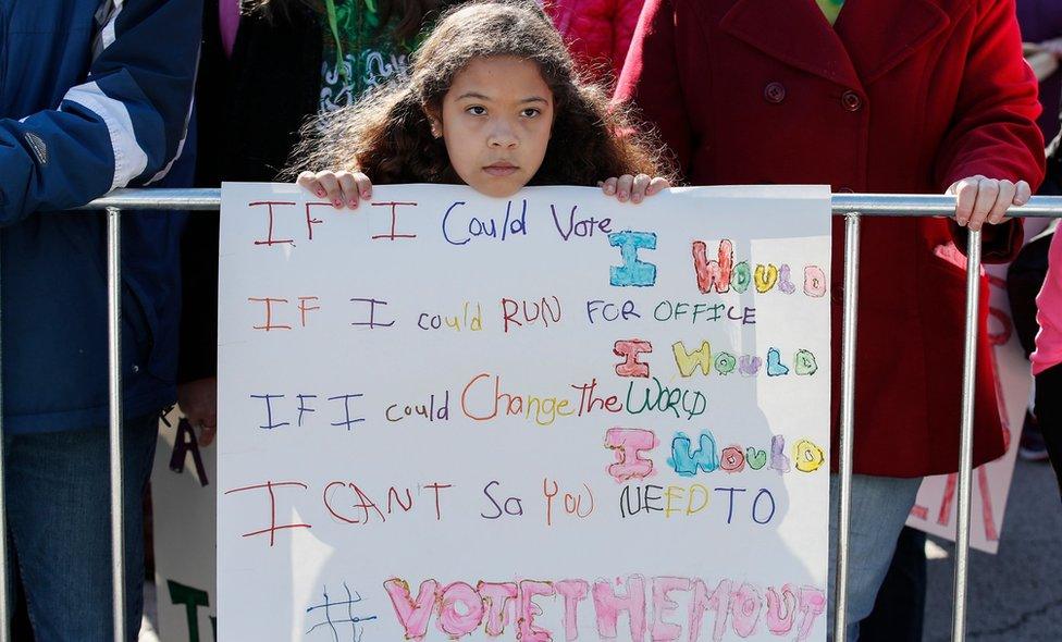 A young girl listens as women gather for a rally and march at Grant Park on October 13, 2018 in Chicago