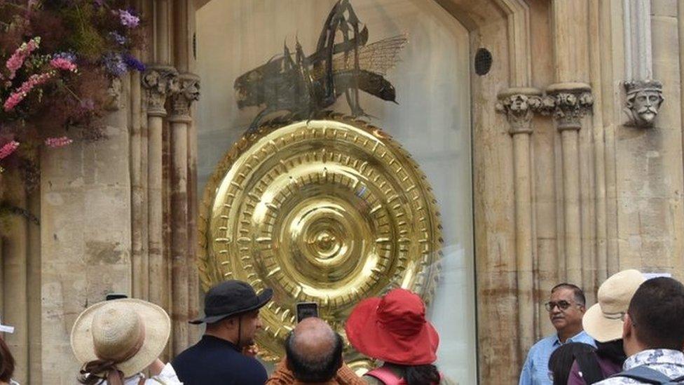 Tourists crowded round the newly returned Corpus Chronophage in Cambridge