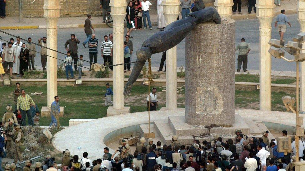 Iraqis watch a statue of Iraqi President Saddam Hussein falling in Baghdad"s al-Fardous (paradise) square 09 April 2003.