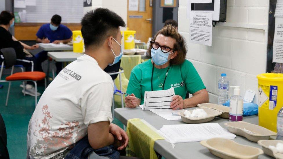 A St John's Ambulance volunteer prepares to administer a Covid vaccine in 2021