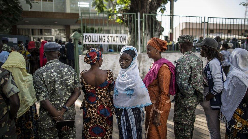 People queue outside a polling station to vote.