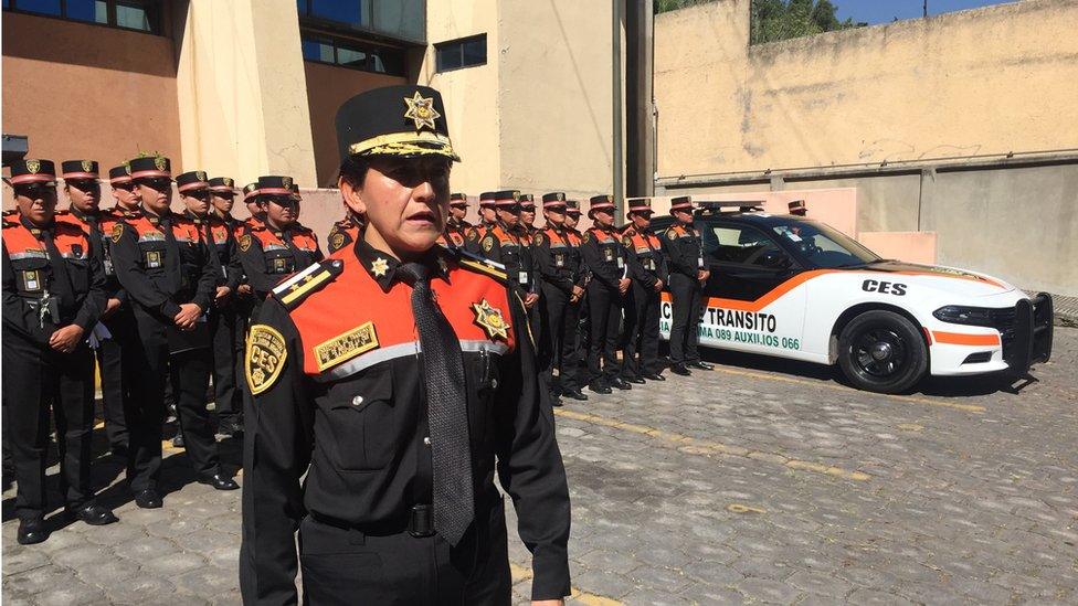 Woman police commanders with squadron of female officers behind her