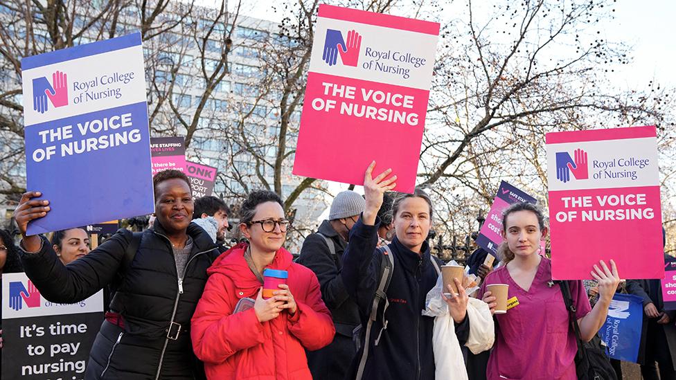 NHS nurses hold placards during a strike, amid a dispute with the government over pay, outside St Thomas' Hospital in London on 20 December 2022