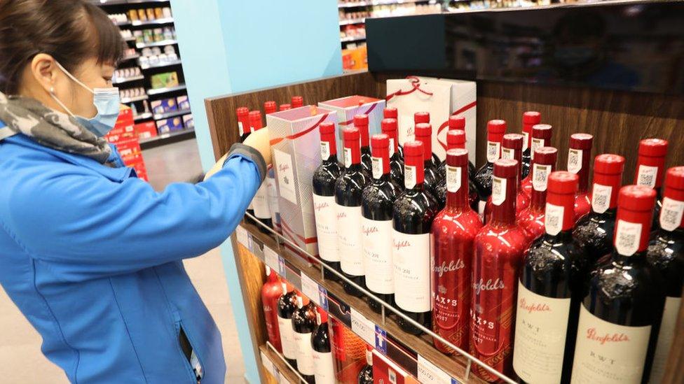 A female customer looks at Australian red wines in a shop in China