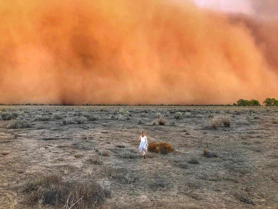 A child running towards a dust storm in Mullengudgery in New South Wales