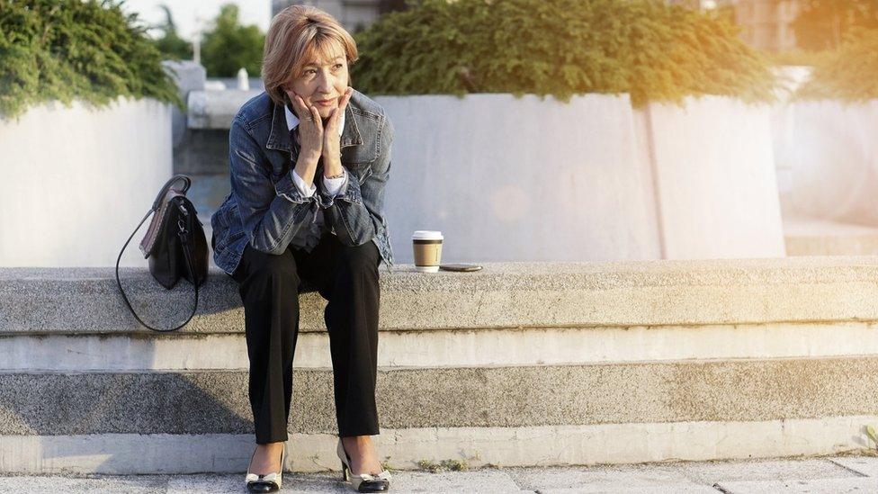 Woman sitting on steps with bag