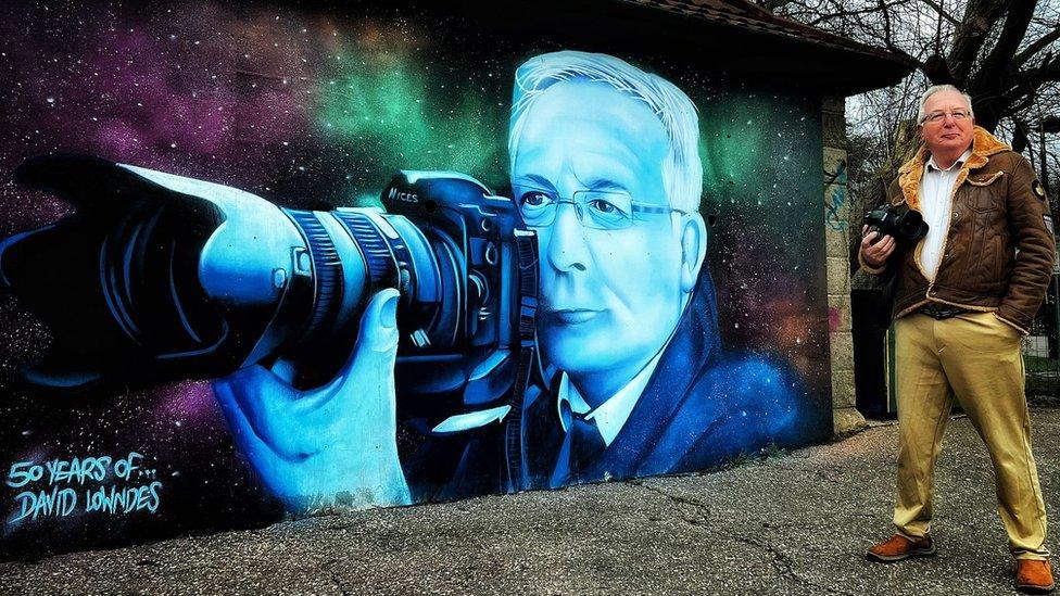 Photographer, David Lowndes, pictured proudly with his mural outside Eastfield Road Cemetery