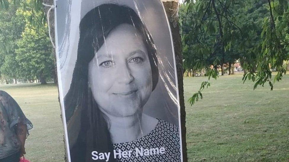 Photo of Dr Antonella Castelvedere with the caption "say her name", which has been attached to a tree in Abbey Fields, Colchester, 17/06/22