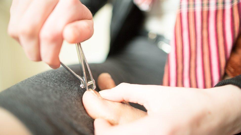 A man clipping toenails