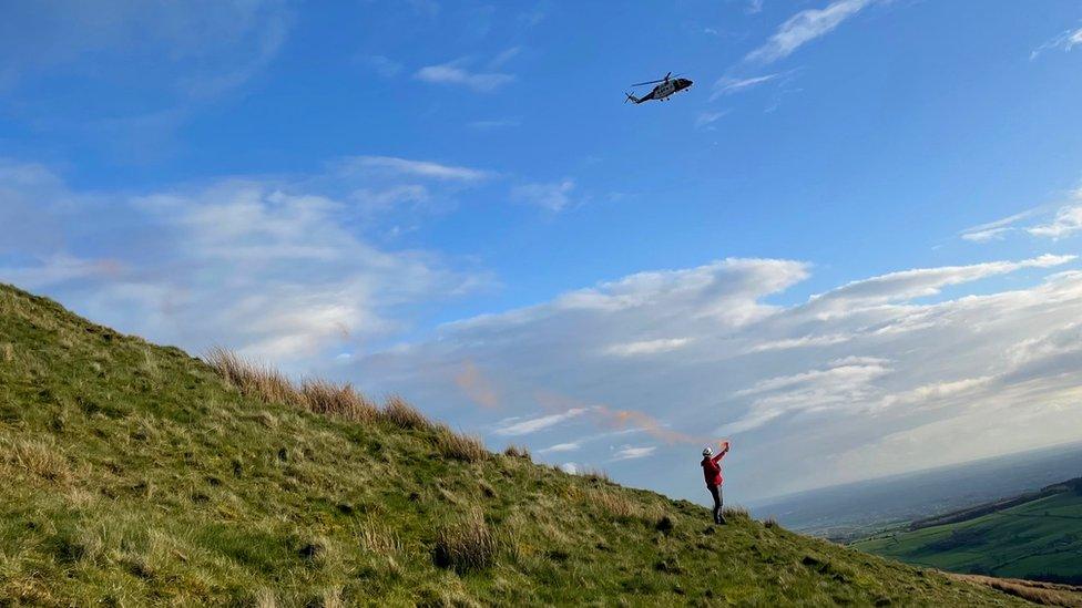 Man uses flare to guide a helicopter