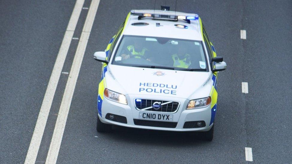 A police car driving along the road