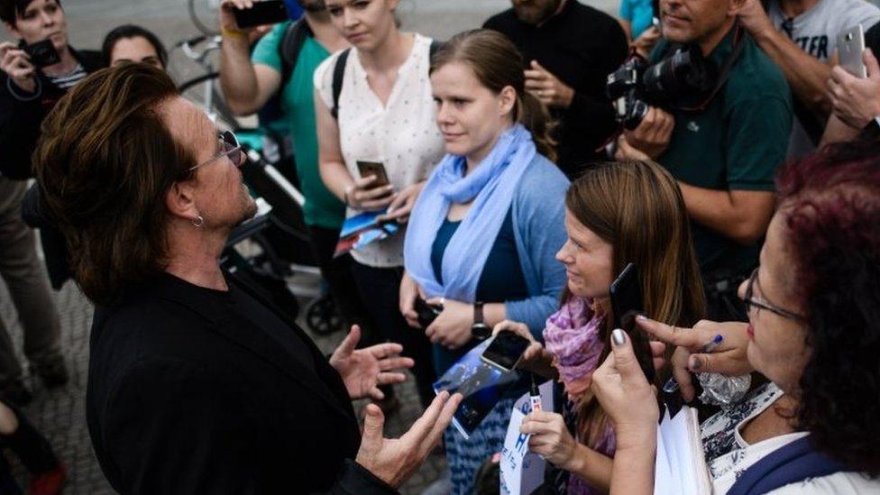 The singer of the Irish rock group U2 talks to fans after a visit to German Chancellor Angela Merkel (not in the picture), in front of the chancellery in Berlin, Germany, 28 August 2018