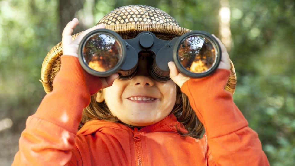 child looking at binoculars