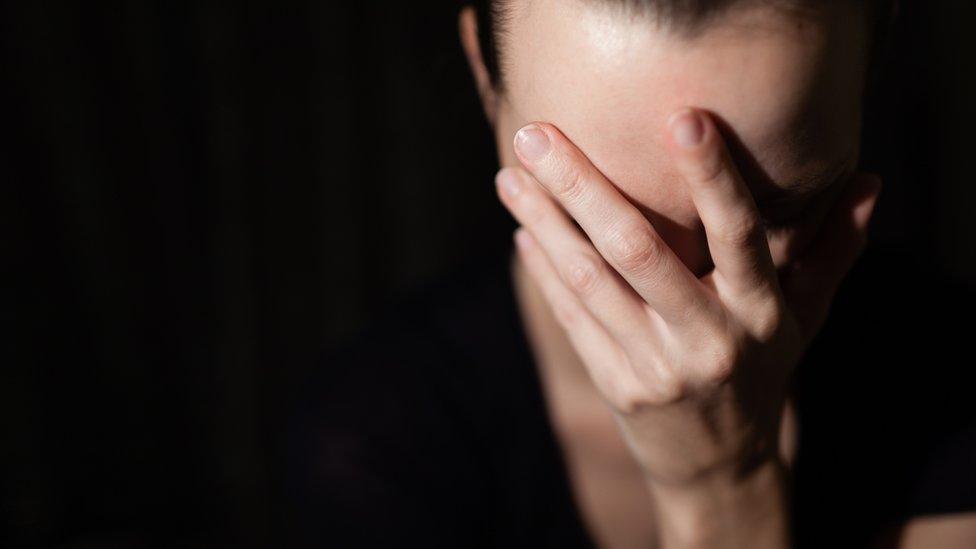 Woman covering her face with her hand