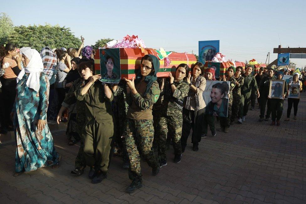 Syrian Kurd women fighters carry the coffin of a comrade killed in Manbij at a funeral in Qamishly, 13 August