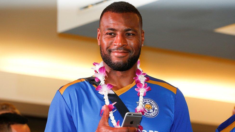 Leicester City's Wes Morgan gestures as he arrives at the airport in Bangkok (May 18 2016).