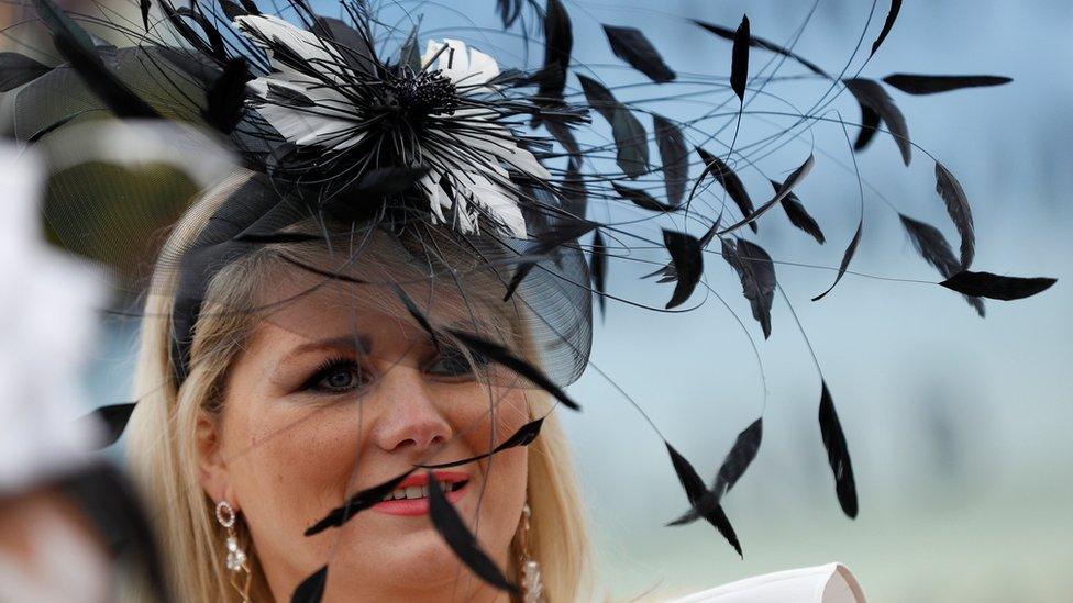 A woman wearing a hat with leaves sprouting from it