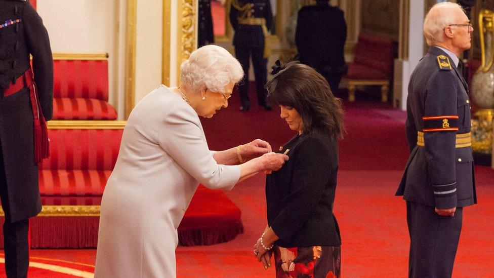 The Queen giving out an MBE