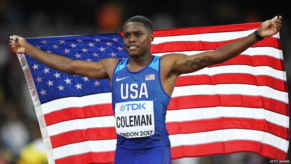 This is a photo of athlete Christian Coleman holding up the American flag.