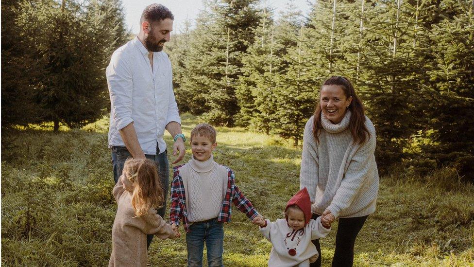 Karen and James Marks playing outside with their three young children