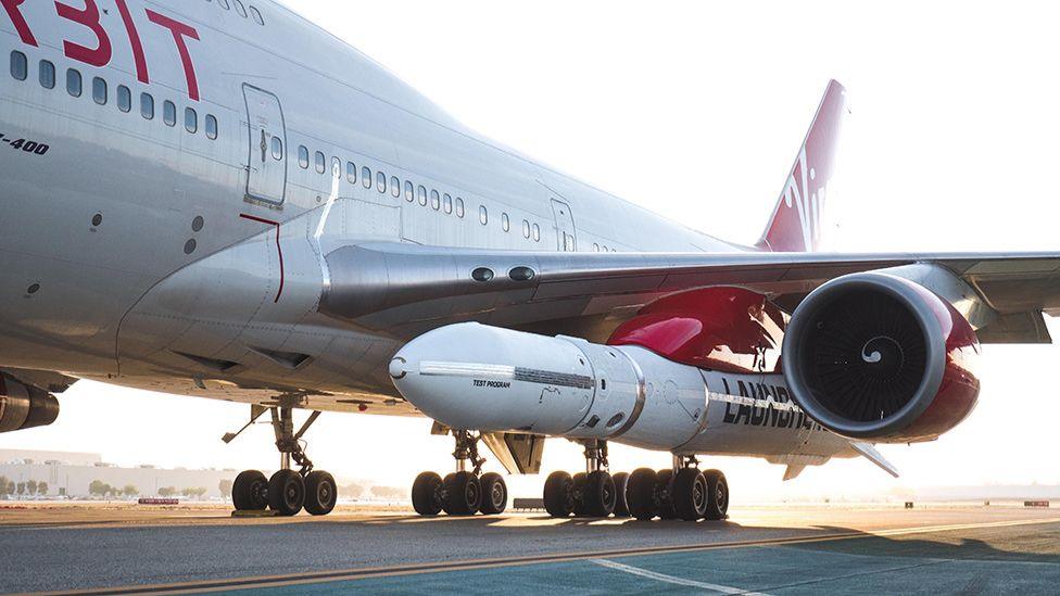 The LauncherOne rocket is carried aloft under the jumbo's port wing