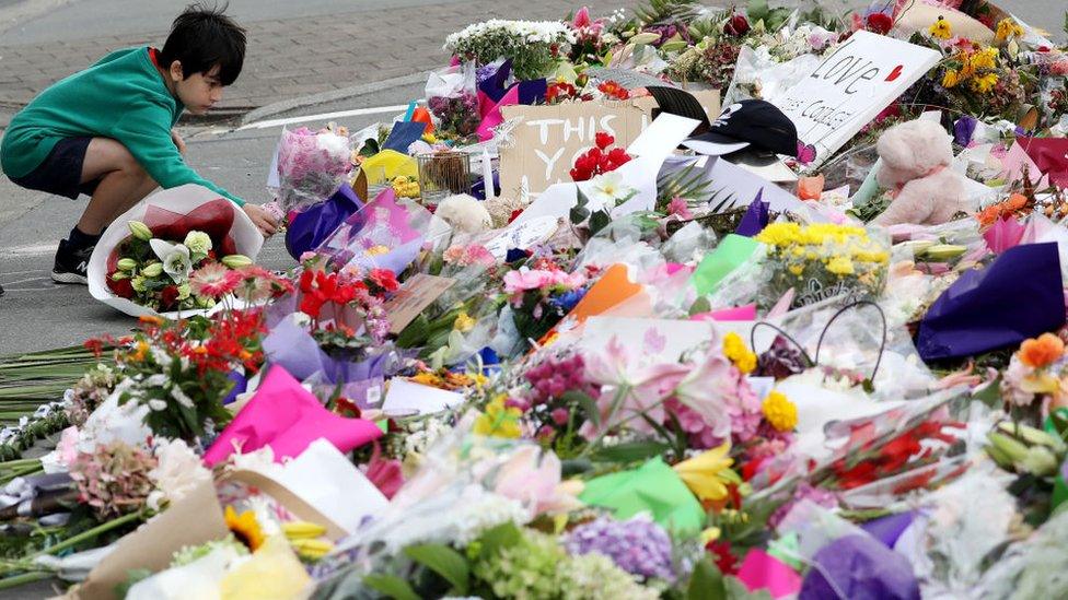 A little boy places flowers at a memorial outside the Linwood Mosque in Christchurch, New Zealand