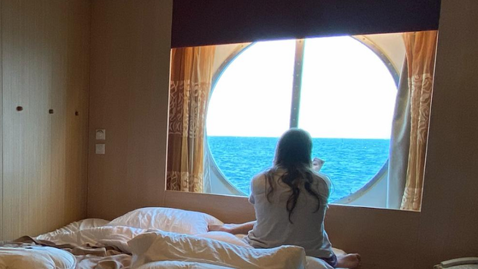 Jessica Furlan stares out of a window in a cabin room on the Celebrity Infinity