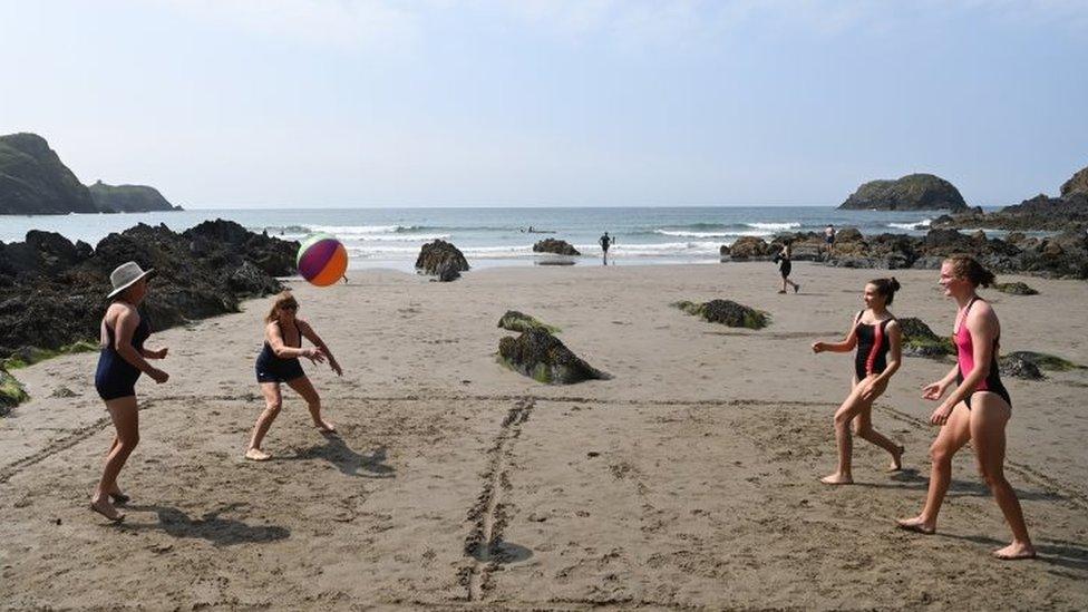 Beachgoers play volleyball in Traeth Llyfn beach in Pembrokeshire