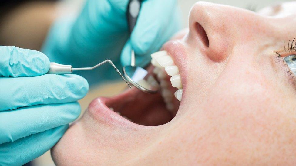 A woman's mouth and dentist